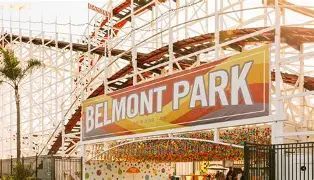 Belmont Park entrance sign with a colorful roller coaster behind it.