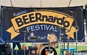 Stage at a Beernado Festival with guitars and a drum kit in front of a large BEERnado FESTIVAL banner.